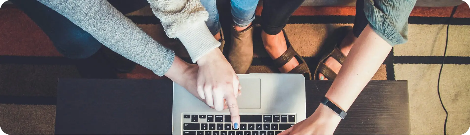 People gathered around a laptop